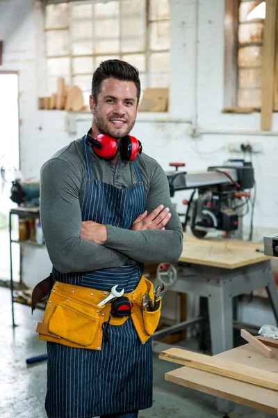 Carpenter smiling and crossing arms