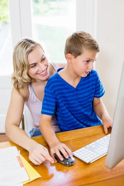 Mother and son using computer in living room