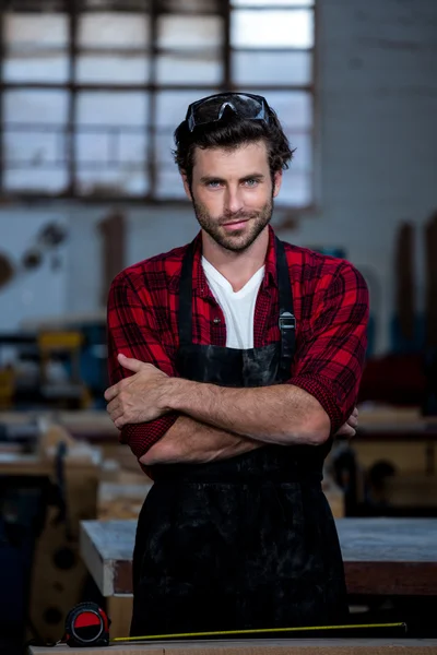 Carpenter smiling and crossing arms