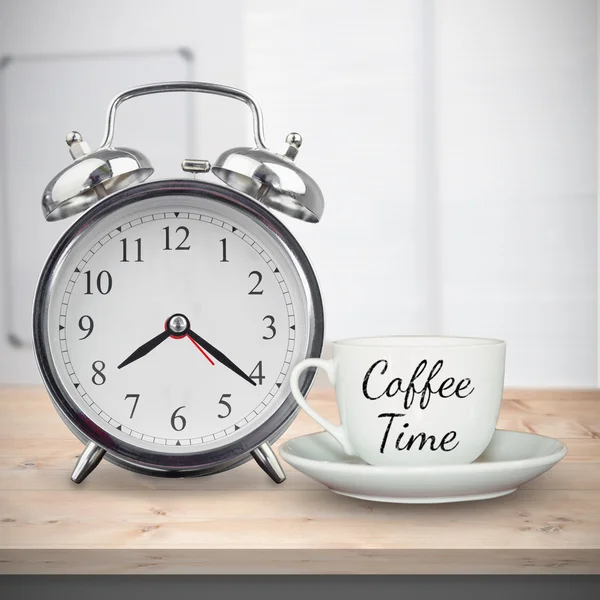 Coffee cup and alarm clock on desk