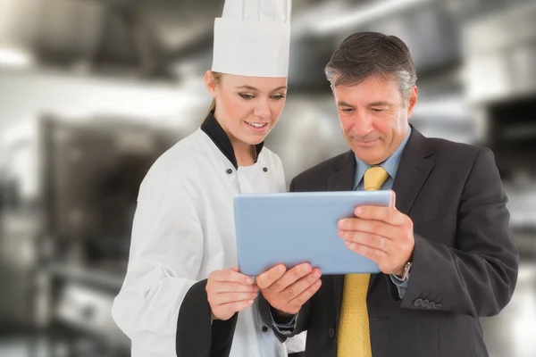 Businessman and female chef using digital tablet