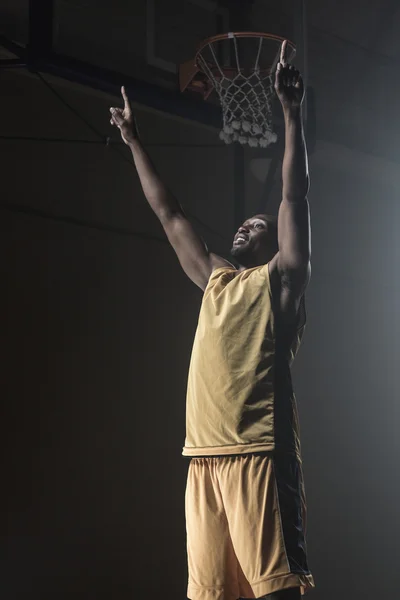 Portrait of basketball player throwing arms for the victory