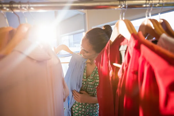 Woman selecting an apparel while shopping for clothes