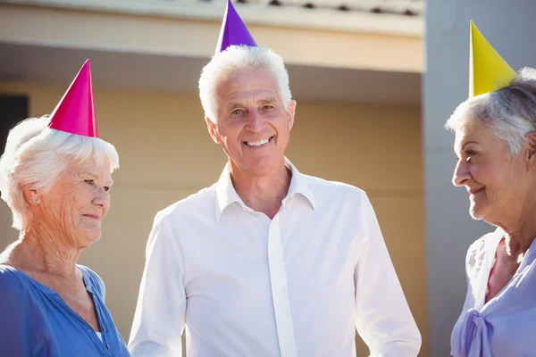 Portrait of seniors smiling with party hats on head