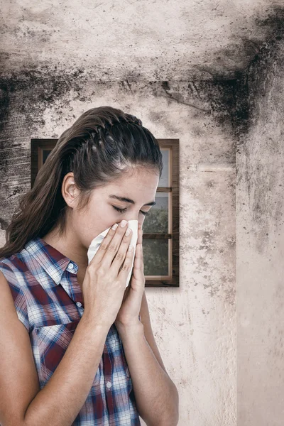 Sick woman sneezing in a tissue