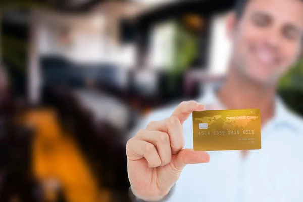 Happy businessman showing a credit card