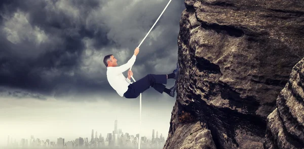 Businessman pulling rope while sitting on cube