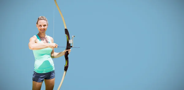 Sportswoman posing with a bow