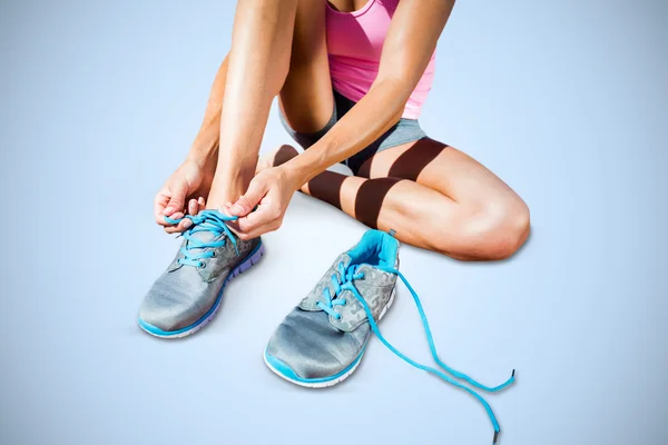 Athletic woman lacing up shoes