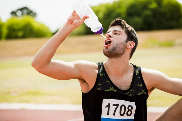 Tired athlete drinking water