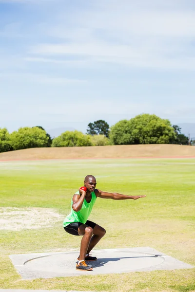 Athlete preparing to throw shot put ball