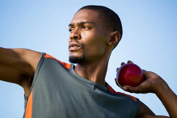 Athlete about to throw shot put ball