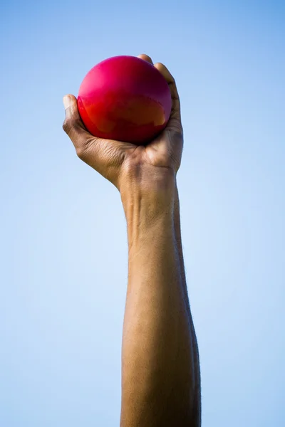 Athletes hand holding shot put ball