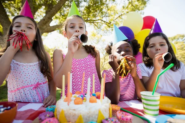 Children breathing out in birthday trumpets