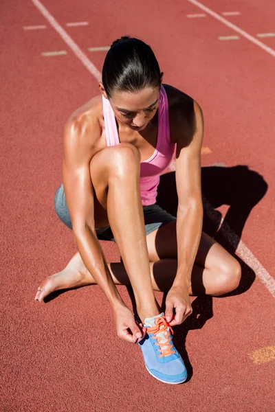 Female athlete tying running shoes