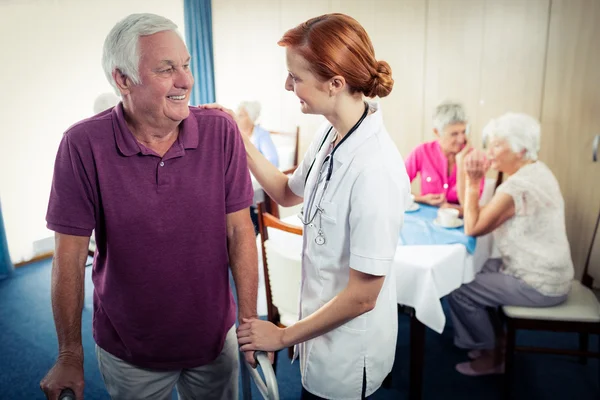 Nurse assisting senior using walker