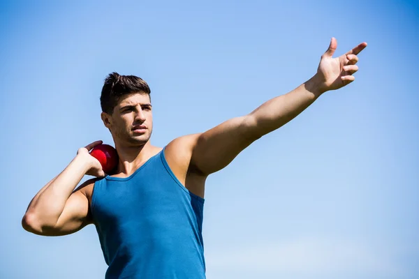 Athlete about to throw shot put ball