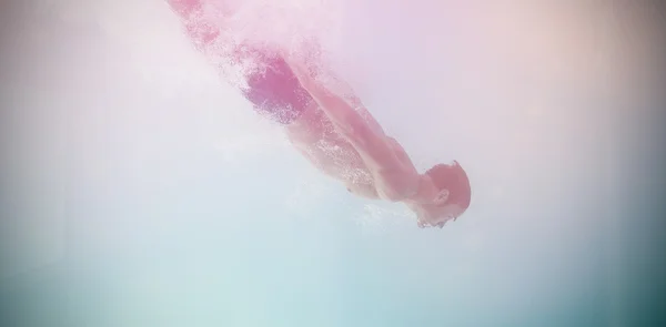 Shirtless man swimming underwater