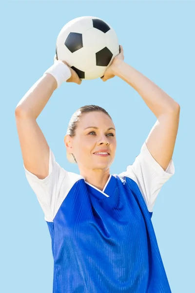 Woman soccer player holding a ball