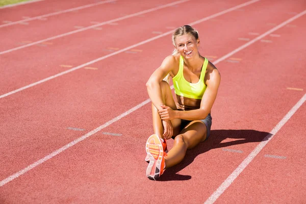 Female athlete sitting on the running track