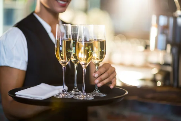 Waitress holding tray with champagne flutes