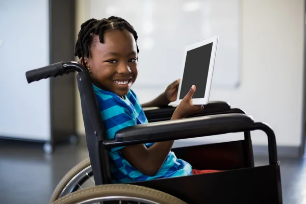 Schoolboy on wheelchair and using tablet