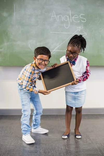 Two smiling school kids holding slate