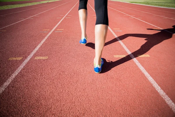 Female athlete feet running on the running track