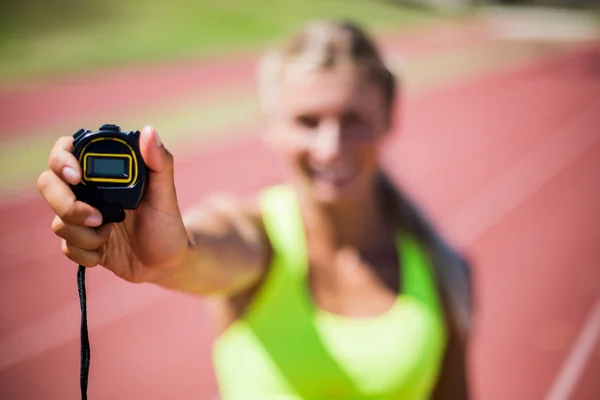 Female athlete showing stop watch