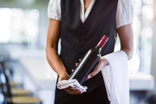 Waitress holding bottle of wine