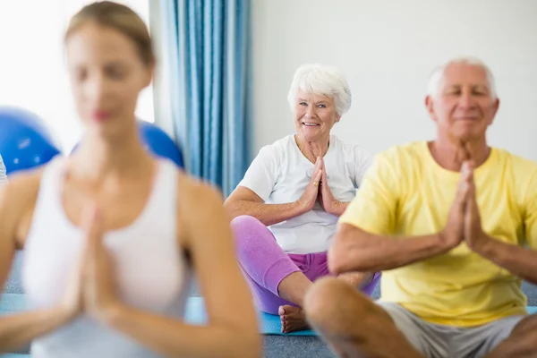 Instructor performing yoga with seniors