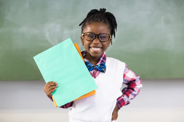 Schoolgirl holding file in classroom