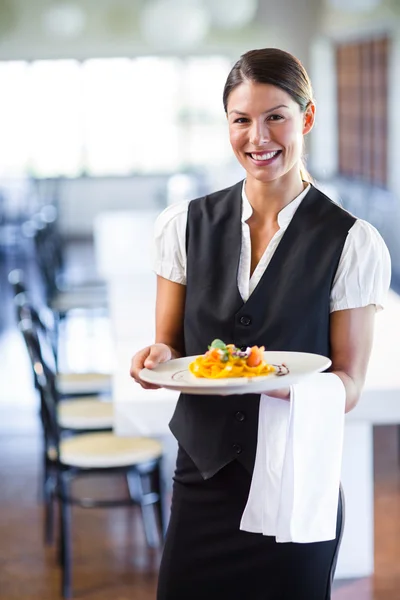 Waitress holding plate in restaurant