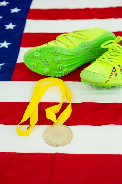 Trainer shoes and gold medal on american flag