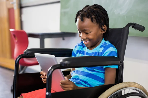 Schoolboy on wheelchair using tablet