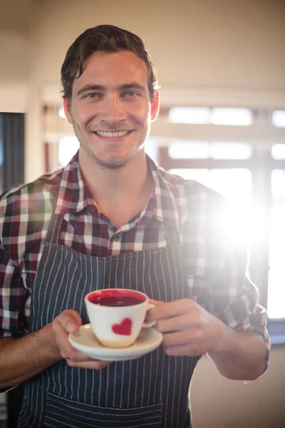 Waiter holding coffee cup at counter