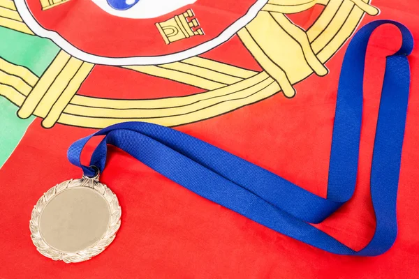 Close-up of gold medal on portugual flag