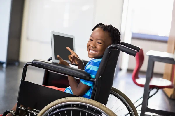 Schoolboy on wheelchair using tablet