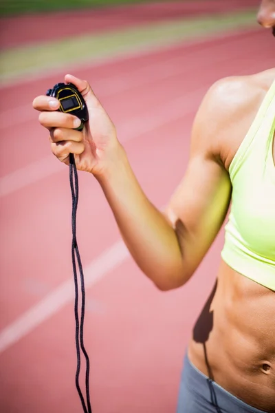 Mid-section of woman holding stop watch