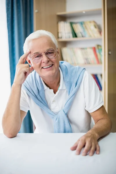 Smiling senior man sitting at table