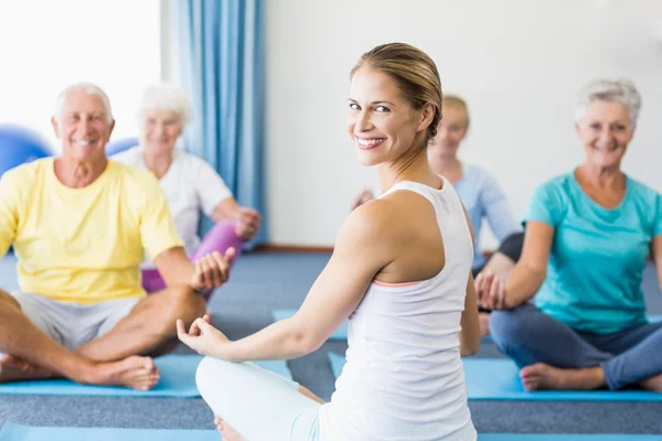 Instructor performing yoga with seniors