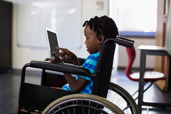 Schoolboy on wheelchair using tablet