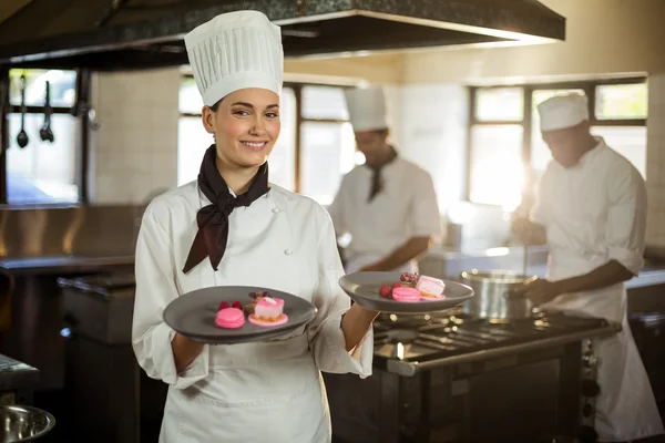Female chef presenting dessert plates