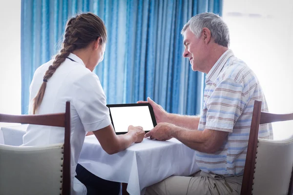 Senior man and female doctor using digital tablet
