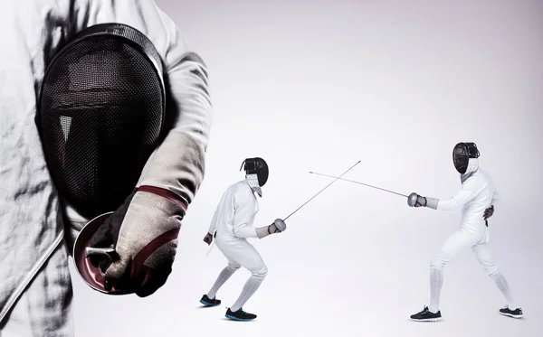 Men in fencing suits practicing with swords