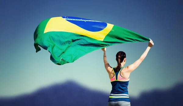Sportswoman raising brazilian flag