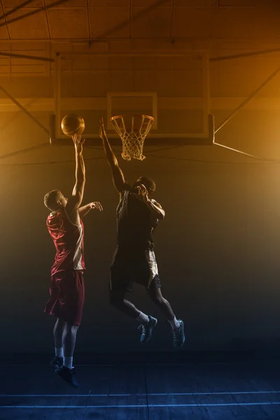Basketball players trying to scoring basket