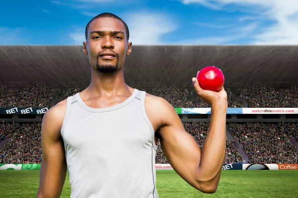 Serious sportsman holding shot put