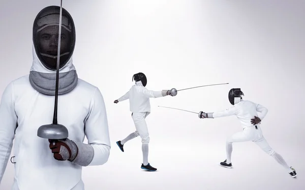 Men in fencing suits practicing with swords