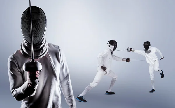 Men in fencing suits practicing with swords